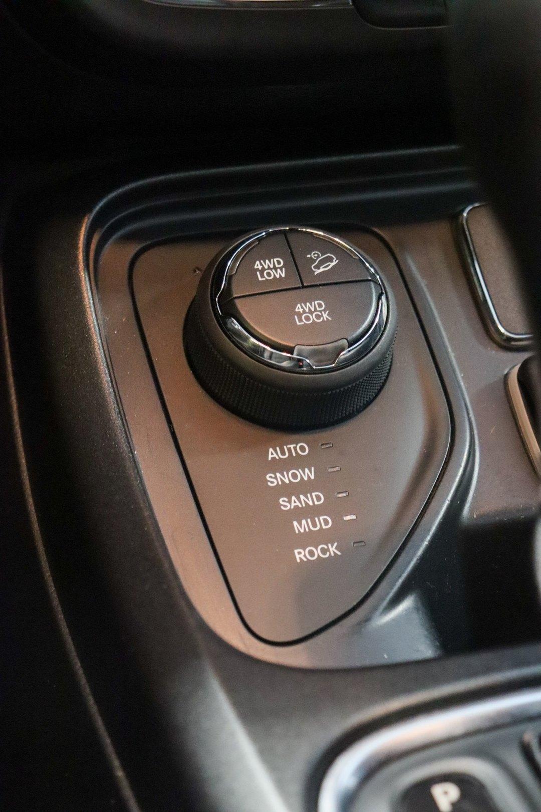 Console central com seletor giratório de modos de terreno Auto, Snow, Sand, Mud e Rock, botões de 4WD Low, 4WD Lock e controle de descida